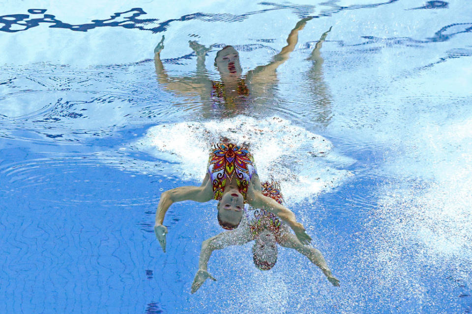 Two swimmers with their arms out appear twice, facing up and down