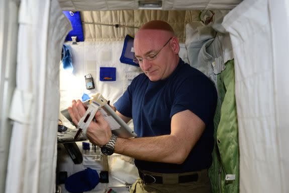 Scott Kelly looks at a tablet in his quarters on the Space Station.