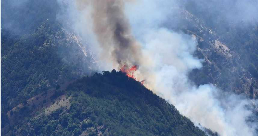 南投大水窟山杜鵑營地發生森林火災，正進行空援搶救，山頭仍見火光濃煙。（圖／民眾提供）