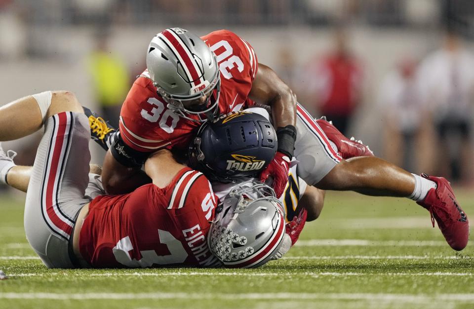 Toledo wide receiver DeMeer Blankumsee (0) is tackled by Ohio State linebackers Tommy Eichenberg (35) and Cody Simon (30) during a game at Ohio Stadium. (Barbara Perenic, Columbus Dispatch)