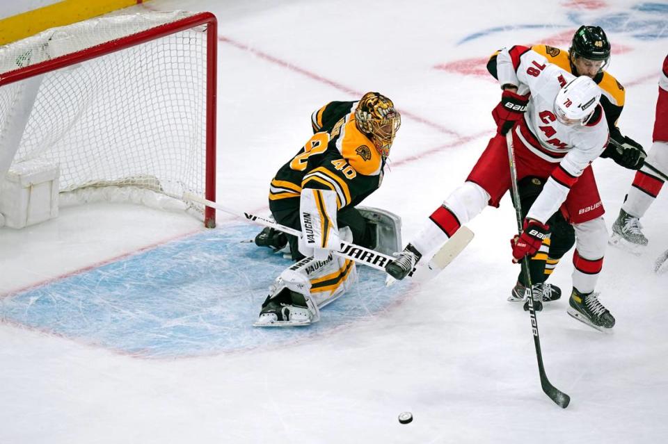 Carolina Hurricanes center Steven Lorentz (78) tries to control the puck as Boston Bruins defenseman Matt Grzelcyk tries to clear in front of goalie Tuukka Rask during the first period of an NHL hockey game, Tuesday, Jan. 18, 2022, in Boston. (AP Photo/Charles Krupa)