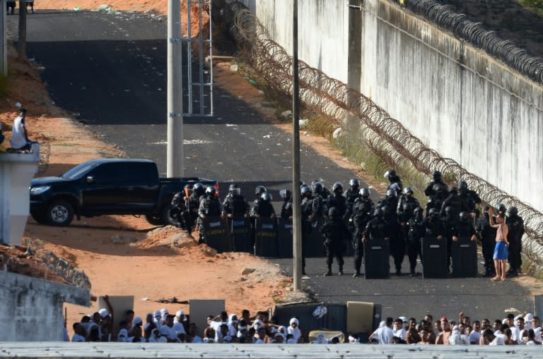 Riot police agents approach to negotiate with an inmate's delegate (R) during a rebellion at the Alcacuz Penitentiary Center near Natal, northeastern Brazil on January 16, 2017