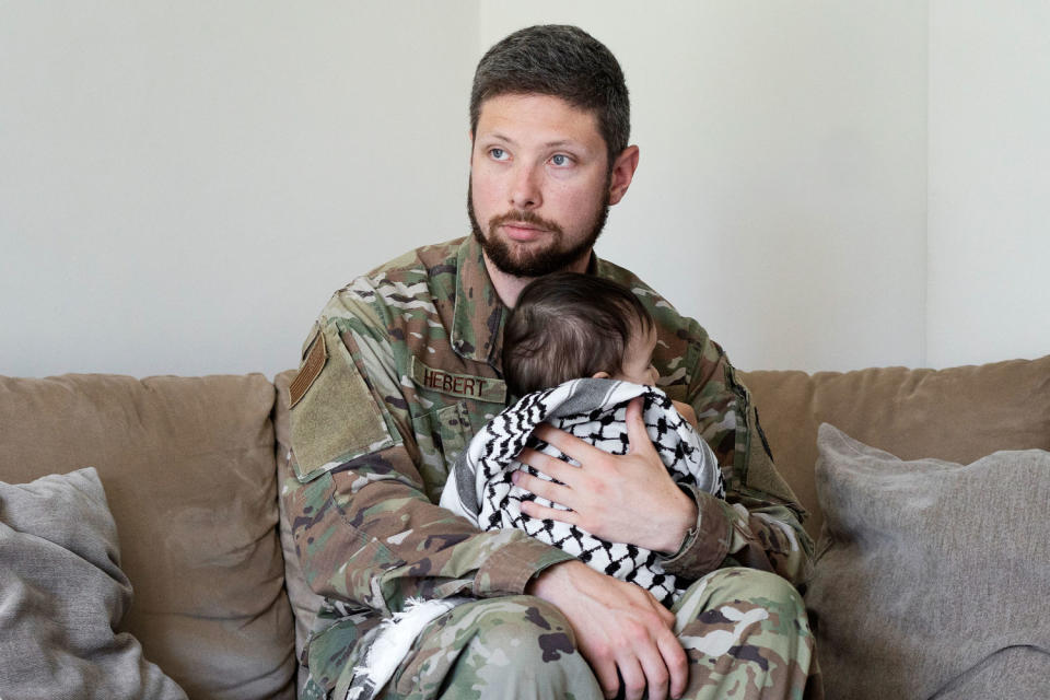 Larry Hebert, an active duty U.S. service member, with his daughter wrapped with a keffiyeh in his home in Rota, southern Spain on Thursday. (Laura León for NBC News)