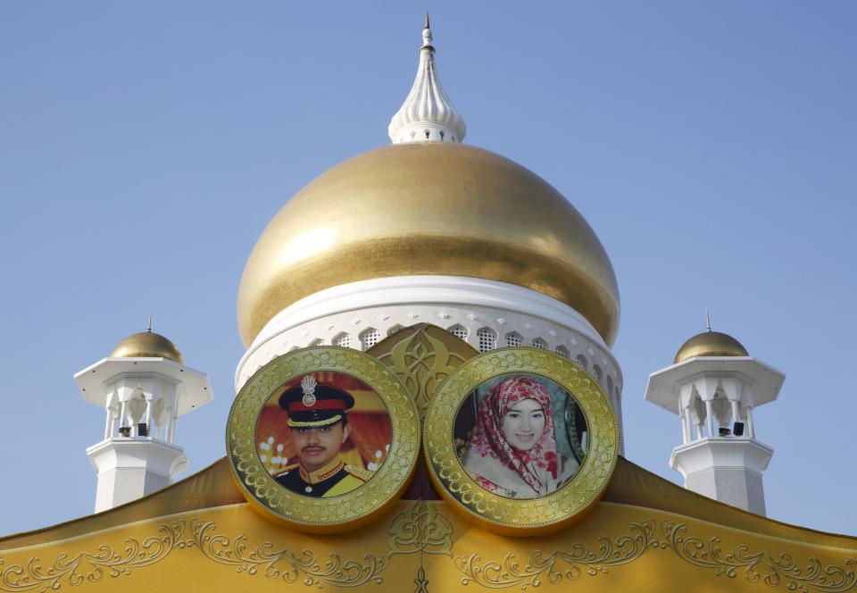 Las fotos del príncipe de Brunei, Prince Abdul Malik y su novia Dayangku Raabi'atul 'Adawiyyah Pengiran Haji Bolkiah se observan frente a la mezquita del sultán Omar Ali Saifuddien. REUTERS/Olivia Harris