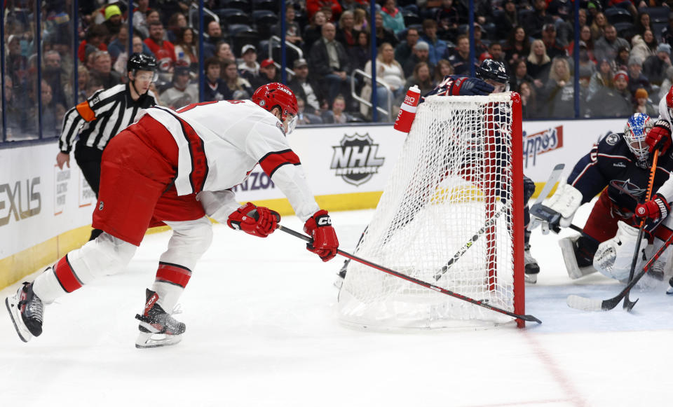 Carolina Hurricanes defenseman Brent Burns, left, scroes behind Columbus Blue Jackets goalie Joonas Korpisalo during the first period of an NHL hockey game in Columbus, Ohio, Thursday, Jan. 12, 2023. (AP Photo/Paul Vernon)