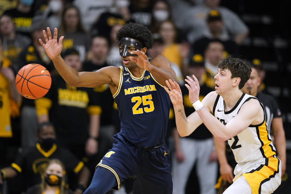 Michigan guard Jace Howard (25) fights for a loose ball with Iowa forward Patrick McCaffery, right, during the first half of an NCAA college basketball game, Thursday, Feb. 17, 2022, in Iowa City, Iowa. (AP Photo/Charlie Neibergall)