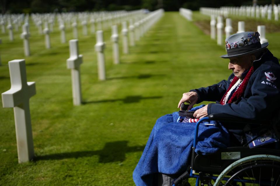 A veteran sits in a wheelchair in a military cemetery