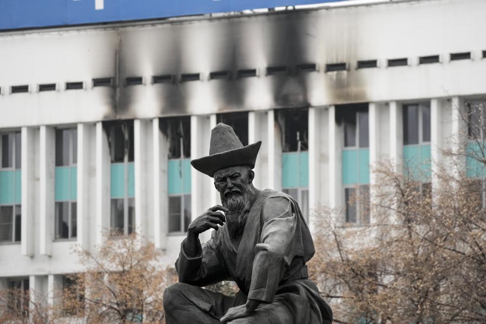 A sculpture of a Kazakhstani man is seen in front of the city hall building in the central square blocked by Kazakhstan troops and police in Almaty, Kazakhstan, Tuesday, Jan. 11, 2022. Authorities in Kazakhstan say nearly 8,000 people were detained by police during protests that descended into violence last week and marked the worst unrest the former Soviet nation has faced since gaining independence 30 years ago. (AP Photo)