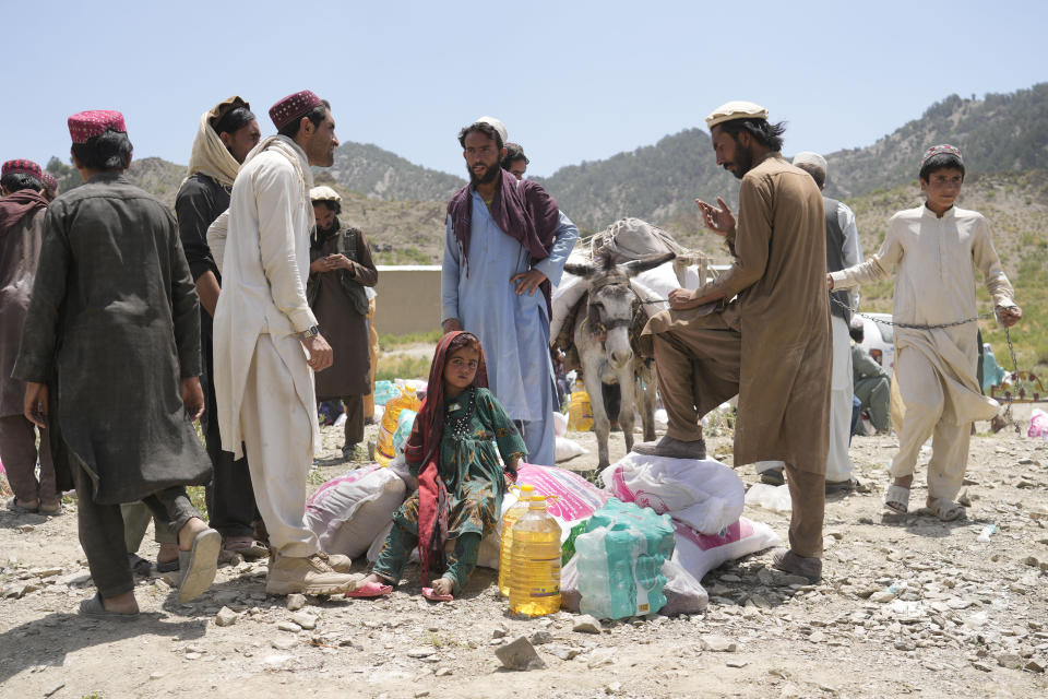 Afghans receive aid at a camp after an earthquake in Gayan district in Paktika province, Afghanistan, Sunday, June 26, 2022. A powerful earthquake struck a rugged, mountainous region of eastern Afghanistan early Wednesday, flattening stone and mud-brick homes in the country's deadliest quake in two decades, the state-run news agency reported. (AP Photo/Ebrahim Nooroozi)