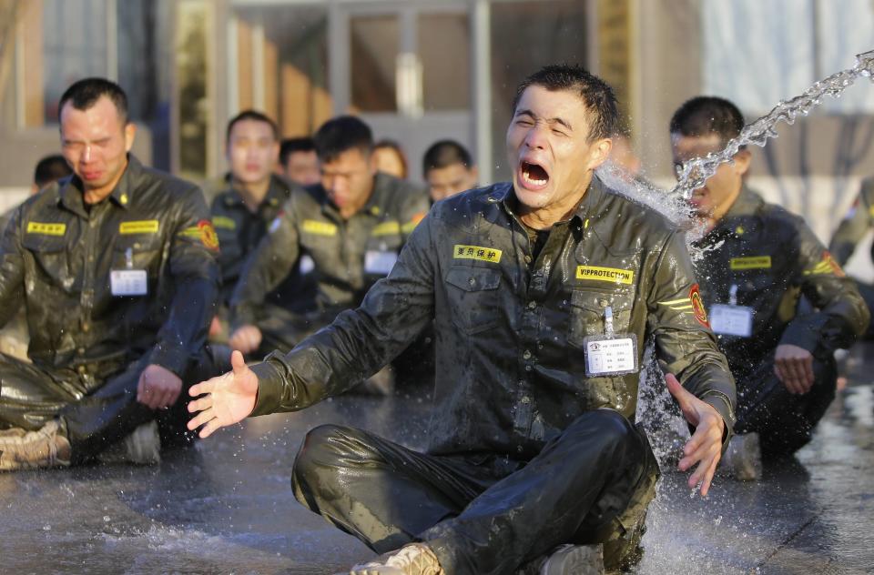 Trainee reacts as he is drenched with water during Tianjiao Special Guard/Security Consultant training on the outskirts of Beijing