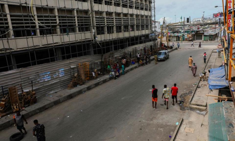 People walk along a closed market during lockdown in Lagos.