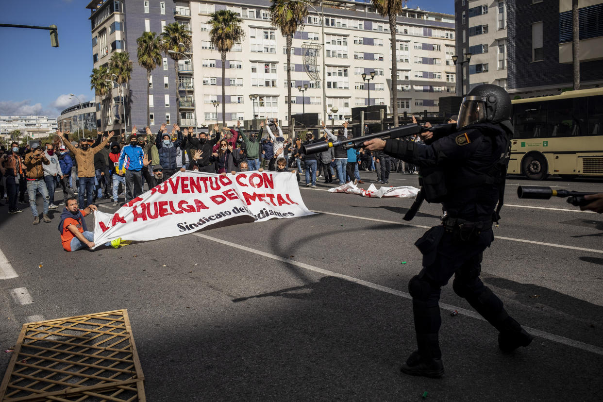 Anti-riot police and protesters clash during a strike organized by metal workers in Cadiz, southern Spain, Tuesday, Nov. 23, 2021. (AP Photo/Javier Fergo)