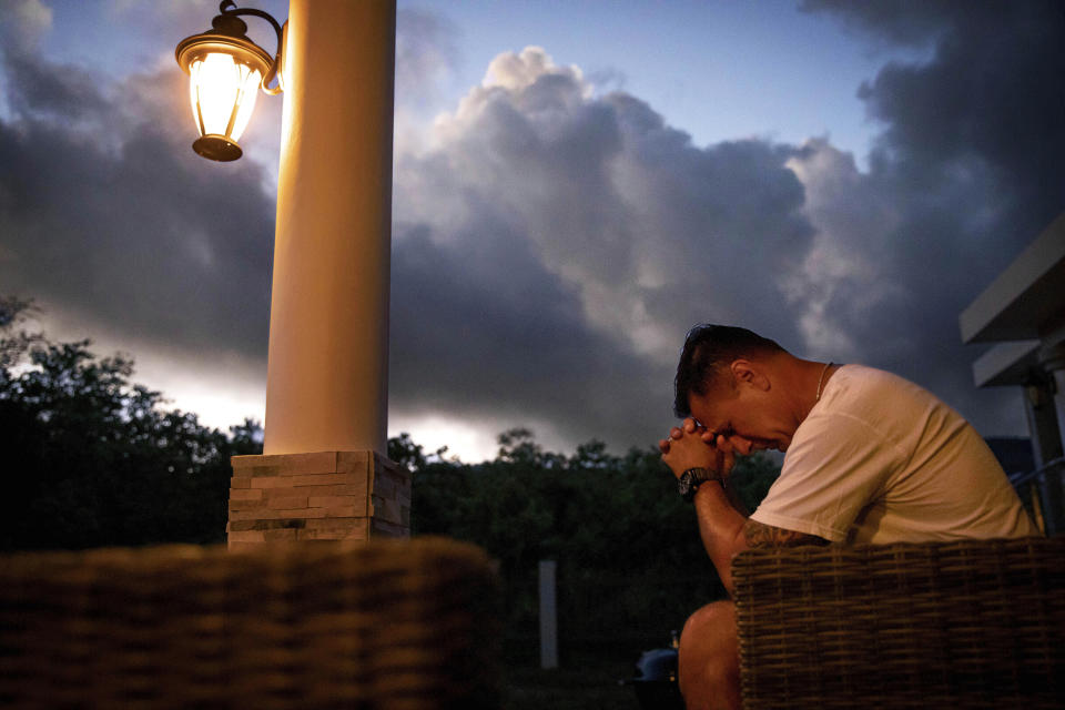 Walter Denton prays as the sun rises in his backyard in Agat, Guam, Saturday, May 11, 2019. Denton is one of over 200 former altar boys, students and Boy Scouts who are now suing Guam's Catholic archdiocese over decades of sexual abuse they say they suffered at the hands of almost three dozen clergy, teachers and scoutmasters. "He took everything from me. From that day forward my demeanor changed. I break down, I hurt everyday and I still hurt," said Denton. But, he adds, "he didn't ruin my faith. I still believe in God." Former Archbishop of Agana, Anthony Apuron denies the allegations. (AP Photo/David Goldman)