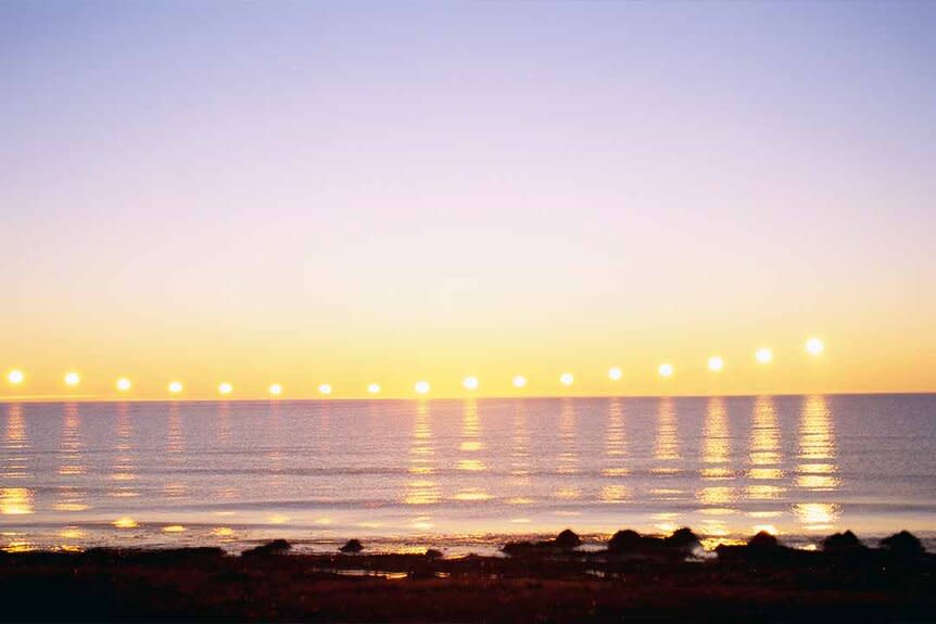 A composite of multiple exposures of the midnight sun moving in Iceland.