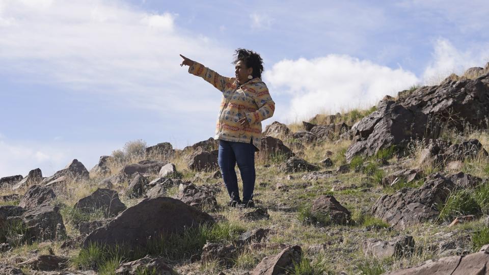 FILE - Michon Eben, historic preservation officer for the Reno-Sparks Indian Colony, looks on near a massacre site at Sentinel Rock on April 25, 2023, outside of Orovada, Nev. The Reno-Sparks Indian Colony is abandoning its 3-year lawsuit aimed at blocking a lithium mine currently under construction at Thacker Pass in northwest Nevada. Tribal leaders say the U.S. Interior Department refuses to accept their arguments that the mine's on a sacred site where more than two dozen Paiute and Shoshone ancestors were massacred in 1865. (AP Photo/Rick Bowmer, File)
