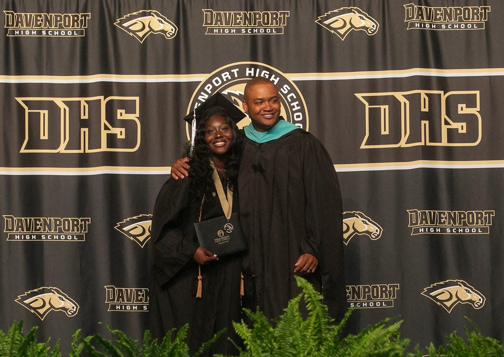 Davenport Principal Alain Douge poses with graduate Jennifer Kamora during the school's commencement ceremony in 2023. Douge, Davenport High's first principal, will take the reins at Lakeland High School after Arthur Martinez retires this year.