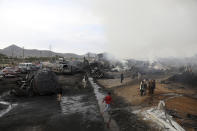 Residents watch burning oil tankers and trucks in Kabul, Afghanistan, Sunday, May 2, 2021. A fire roared through several fuel tankers on the northern edge of the Afghan capital late Saturday, injuring at least 10 people and plunging much of the city into darkness, officials said. (AP Photo/Rahmat Gul)