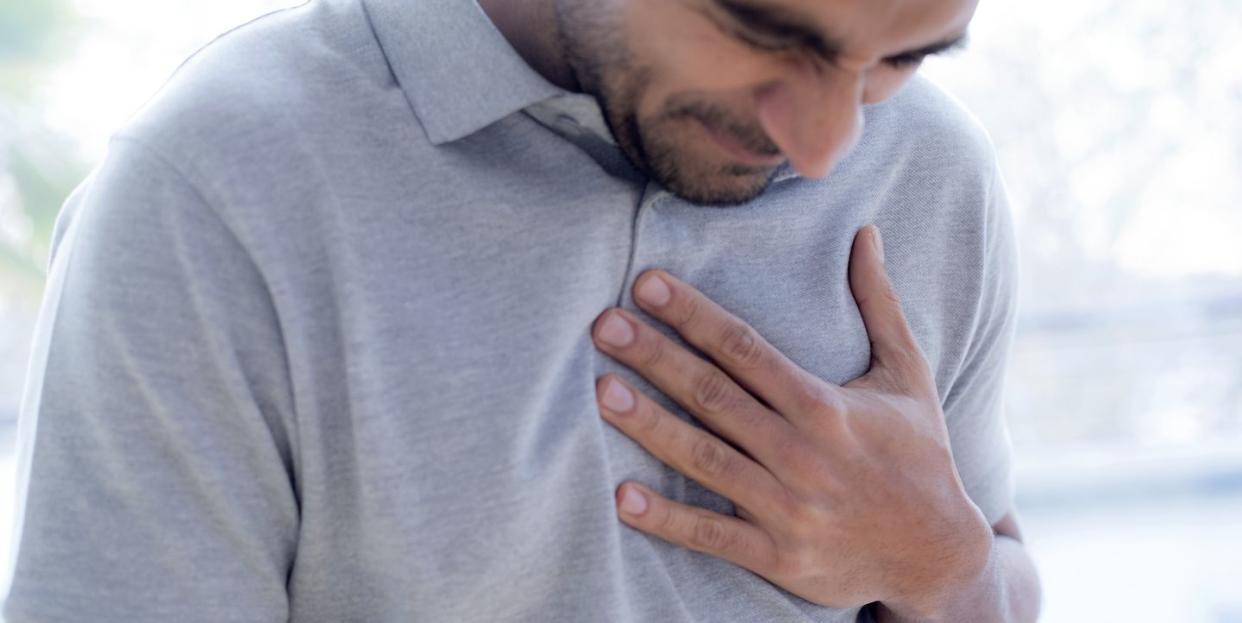 man touching his chest in pain