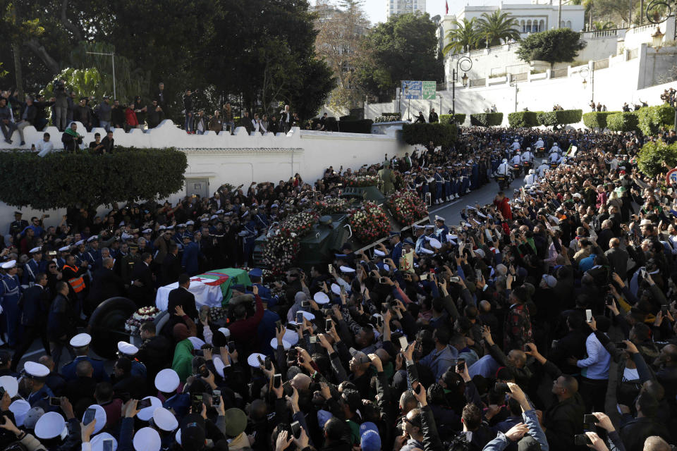 People gather during the funeral Gen. Ahmed Gaid Salah, in Algiers, Algeria, Wednesday, Dec. 25, 2019. Algeria is holding an elaborate military funeral for the general who was the de facto ruler of the gas-rich country amid political turmoil throughout this year. (AP Photo/Toufik Doudou)