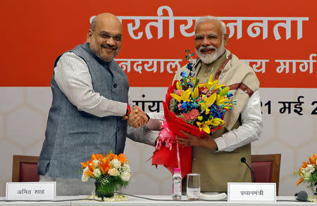 FILE PHOTO: India's Prime Minister Narendra Modi shakes hands with the Bharatiya Janata Party (BJP) President Amit Shah during a thanksgiving ceremony by BJP leaders to its allies at the party headquarters in New Delhi, India, May 21, 2019. REUTERS/Anushree Fadnavis/File Photo