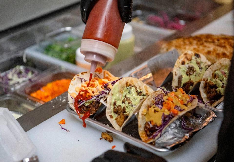 Toppings are added to an order of tacos at Carter’s Table on Wednesday, March 22, 2023.