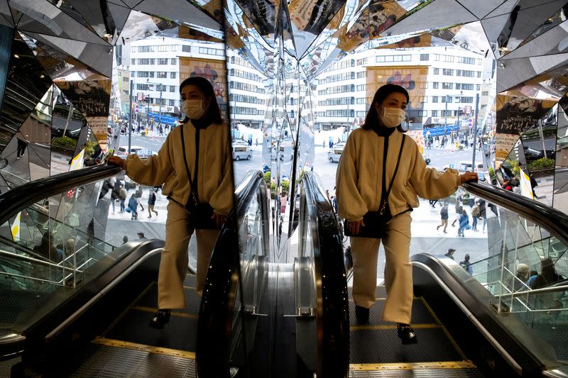 FILE PHOTO: A woman wearing a protective mask, following an outbreak of the coronavirus disease (COVID-19), is reflected in the mirror at a shopping mall in Tokyo