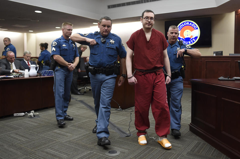 FILE - In this Aug. 26, 2015, file photo, Colorado theater shooter James Holmes, right, is led out of the courtroom after being formally sentenced in Centennial, Colo., to serve life in prison without parole. Holmes was convicted of killing 12 people and injuring 70 in the attack. In a new book and an interview with The Associated Press, psychiatrist William H. Reid, who spent hours talking with Holmes, says what led Holmes to open fire was a vortex of his mental illness, his personality and his circumstances, along with other, unknown factors. (RJ Sangosti/The Denver Post via AP, Pool, File)