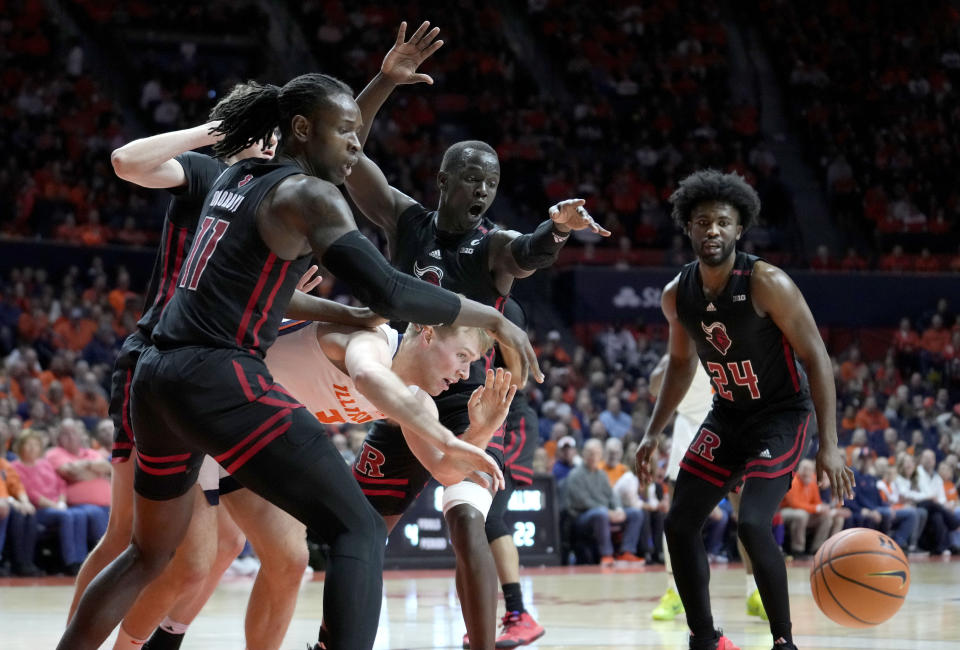 Illinois' Marcus Domask loses control of the ball from pressure by Rutgers' Clifford Omoruyi (11) during the first half of an NCAA college basketball game Sunday, Jan. 21, 2024, in Champaign, Ill. (AP Photo/Charles Rex Arbogast)