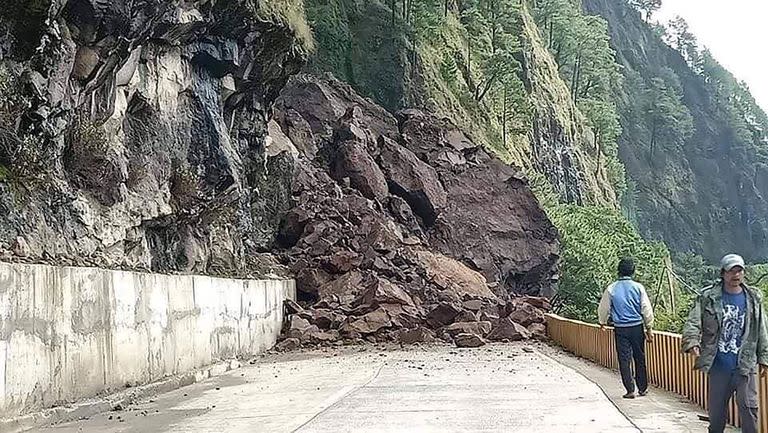 Esta foto tomada y publicada el 27 de julio de 2022 por la Oficina de Gestión de la Reducción del Riesgo de Desastres de la Provincia de las Montañas muestra rocas que bloquean una carretera