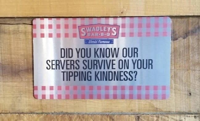 A sign stating that servers are not paid enough to survive and depend on customers' tips