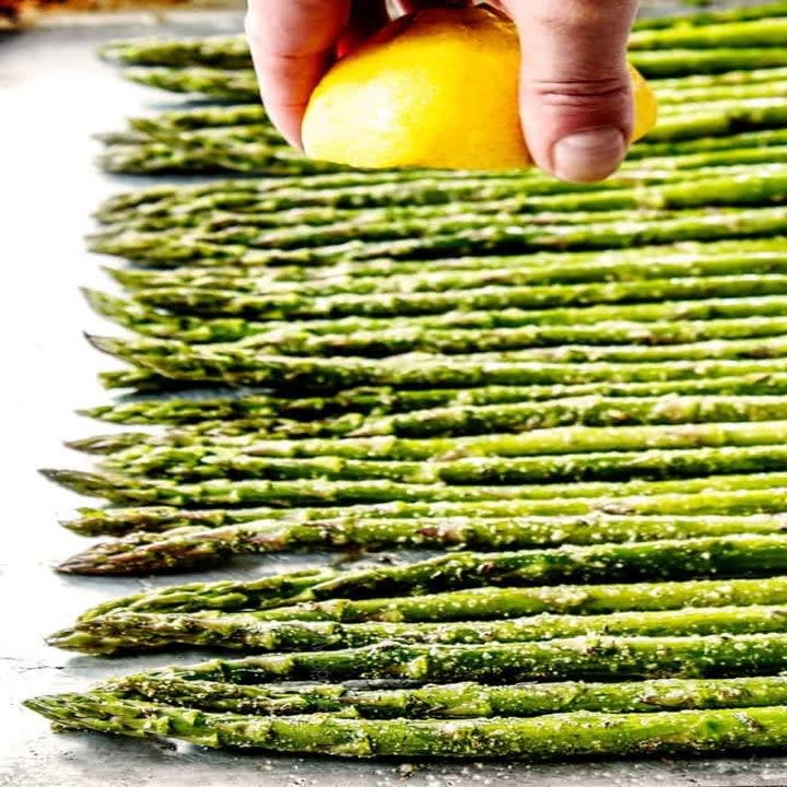 Drizzling asparagus with lemon.