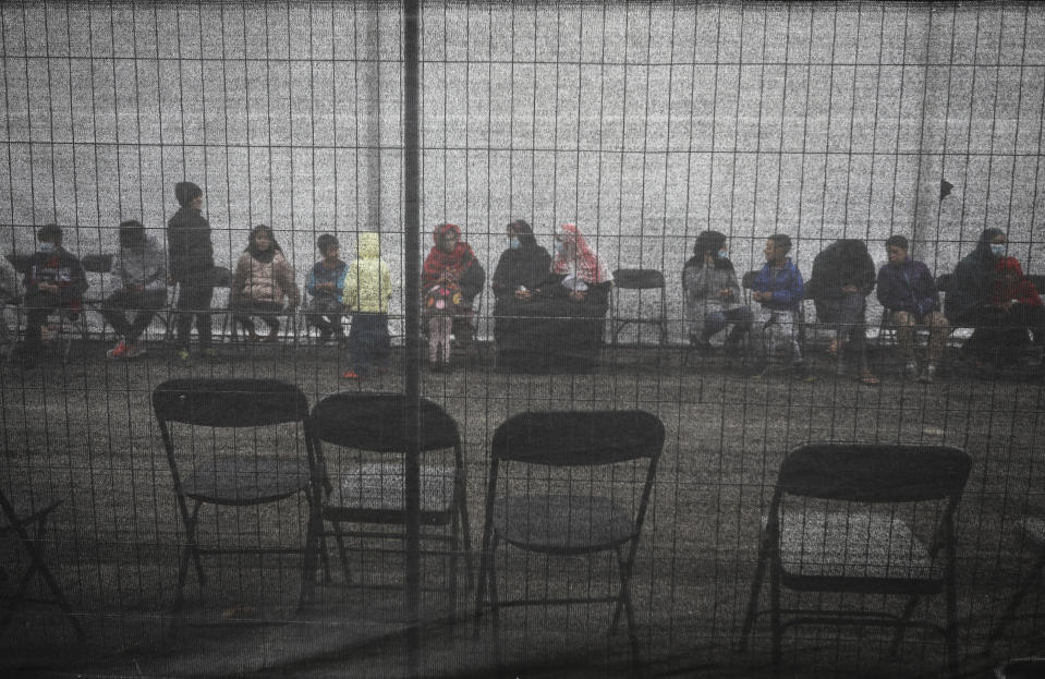 Afghan refugees queue outside a distribution and donation center in Liberty Village on Joint Base McGuire-Dix- Lakehurst in Trenton, N.J., Thursday, Dec. 2, 2021. (Barbara Davidson/Pool via AP)