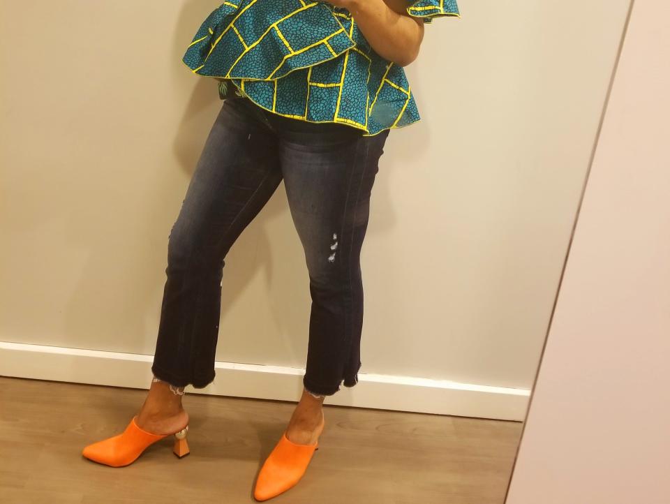 celebrity stylist wearing a geometric shirt and mom jeans with orange heels