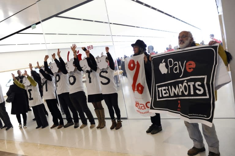 Activists of the Association for the Taxation of Financial Transactions and Citizen's Action stand outside an Apple Store during a protest against tax evasion in December 2017 in Marseille, southern France