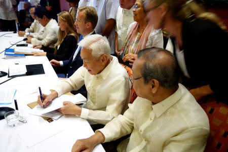 Philippines communist rebel negotiator Luis Jalandoni (2nd R) signs an indefinite ceasefire agreement with the government at a meeting in Oslo, Norway, August 26, 2016. REUTERS/Alister Doyle