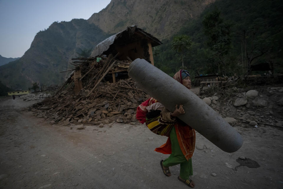 A woman walks past a house damaged in earthquake in Rukum District, northwestern Nepal, Sunday, Nov. 5, 2023. Friday night’s earthquake in the mountains of northwestern Nepal killed more than 150 people and damaged or destroyed most homes. (AP Photo/Niranjan Shrestha)