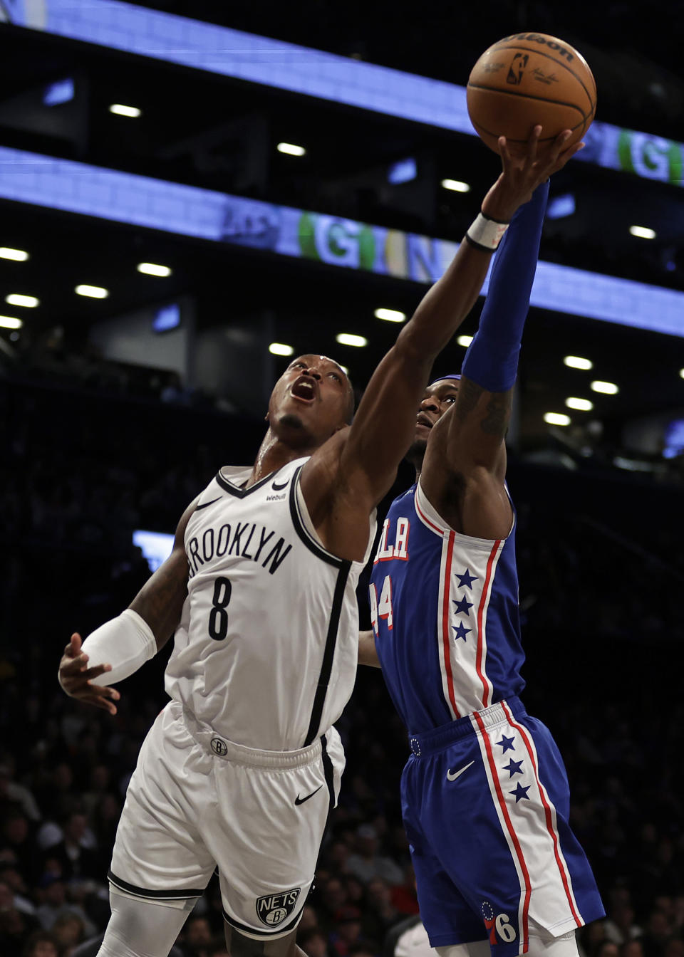 Brooklyn Nets guard Lonnie Walker IV (8) drives to the basket past Philadelphia 76ers forward Paul Reed during the first half of an NBA basketball game Tuesday, March 5, 2024, in New York. (AP Photo/Adam Hunger)