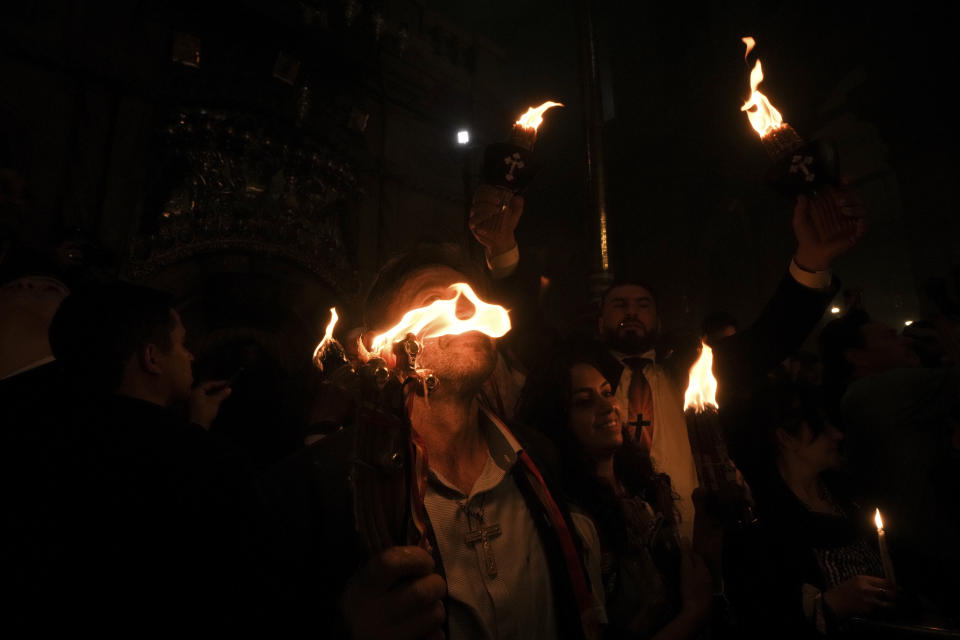 Christian pilgrims hold candles during the Holy Fire ceremony, a day before Easter, at the Church of the Holy Sepulcher, where many Christians believe Jesus was crucified, buried and resurrected, in Jerusalem's Old City, Saturday, April 15, 2023. (AP Photo/Mahmoud Illean)