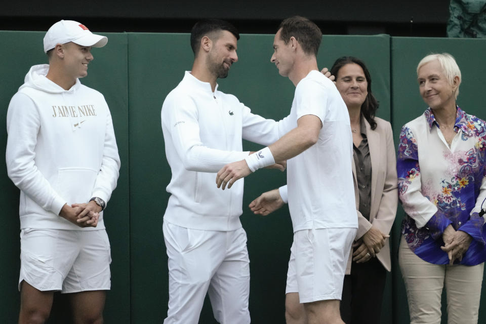 Britain's Andy Murray reacts with Serbia's Novak Djokovic, second left, as Holger Rune, left, of Denmark, and Conchita Martinez of Spain, and Martina Navratilova, right, of the US watch following his first round doubles match at the Wimbledon tennis championships in London, Thursday, July 4, 2024. (AP Photo/Kirsty Wigglesworth)