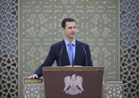 Syria's President Bashar al-Assad places his right hand on a Koran as he is sworn in for a new seven-year term, at al-Shaab presidential palace in Damascus July 16, 2014, in this picture released by Syria's national news agency SANA. REUTERS/SANA/Handout via Reuters