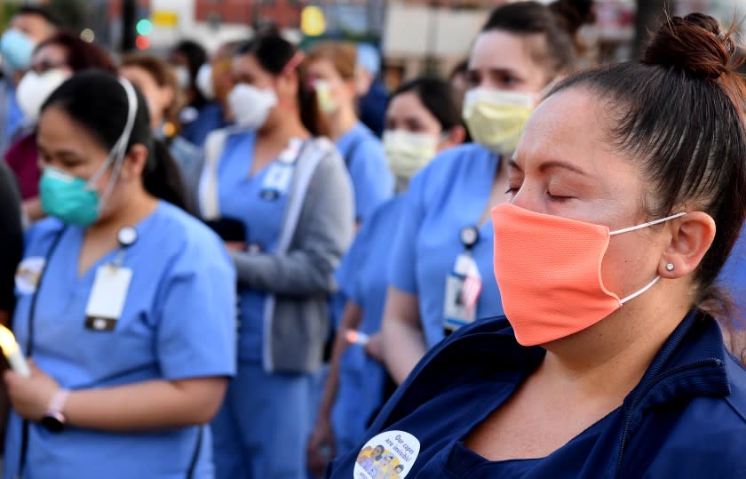 LOS ANGELES, CALIFORNIA MAY 6, 2020-Monique Hernandez, a registered nurse for Riverside Community Hospital, attends a candlelight vigil for nurse Celia Marcos outside Hollywood Presbyterian Medical Center in Los Angeles Wednesday. Marco died from the coronavirus. (Wally Skalij/Los Angeles Times)