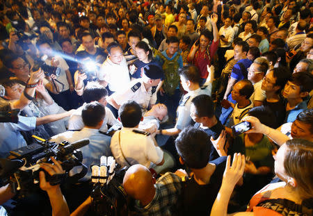 Police remove a man who collapsed during confrontations between anti-Occupy Central protesters and pro-democracy protesters on a main street at Hong Kong's Mongkok shopping district October 3, 2014. REUTERS/Carlos Barria