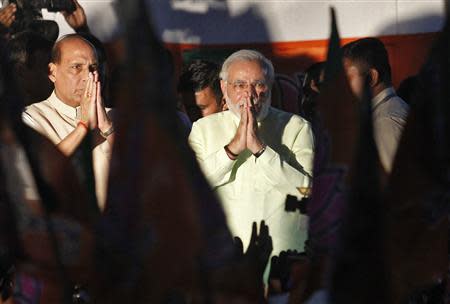 India's Hindu nationalist Narendra Modi (C) and Rajnath Singh (L), president of India's main opposition Bharatiya Janata Party (BJP), greet party supporters after Modi was crowned as the prime ministerial candidate for the BJP at the party headquarters in New Delhi September 13, 2013. REUTERS/Anindito Mukherjee