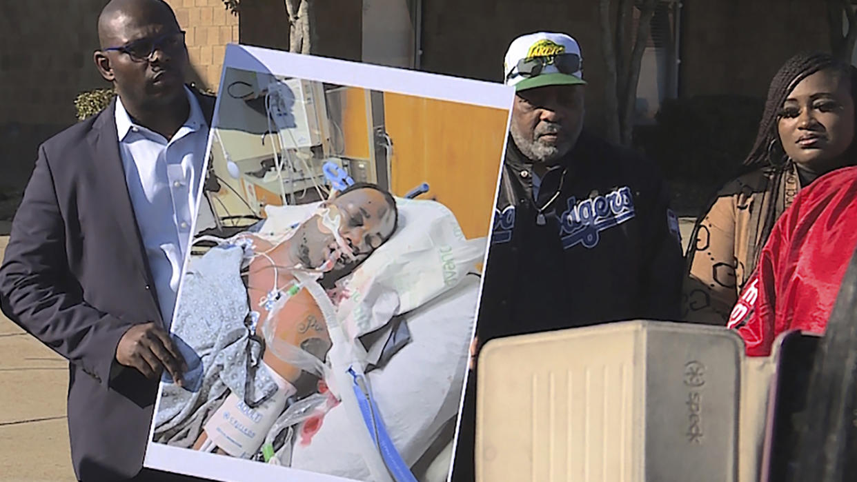 Tyre Nichols's stepfather Rodney Wells, center, with a photo of Nichols in the hospital after his arrest, during a protest in Memphis, Tenn.