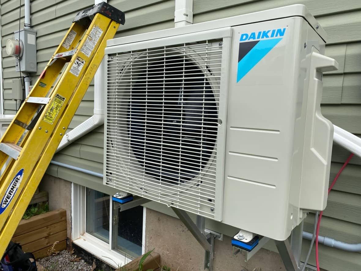 This heat pump was installed at a home in Prince Edward Island. They can act as a replacement for a furnace and/or air conditioner. While the upfront cost may be more money, climate change consultant Heather McDiarmid says operating costs are much lower and a heat pump is better for the environment. (Danny Arsenault/CBC - image credit)