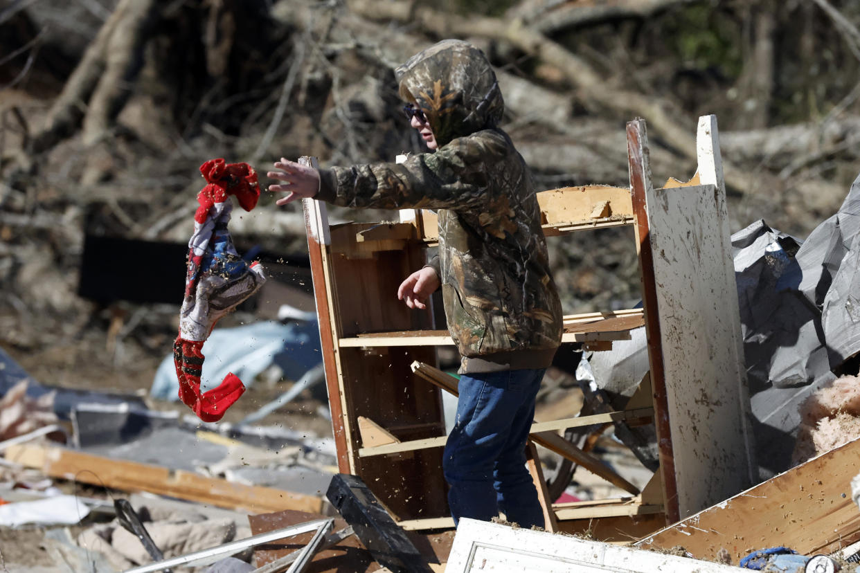 John Henderson, helps sift through debris looking for personal items as they recover from a tornado that ripped through Central Alabama earlier this week Saturday, Jan. 14, 2023 in Marbury, Ala. Stunned residents tried to salvage belongings as rescue crews pulled survivors from the aftermath of a deadly tornado-spawning storm system. (AP Photo/Butch Dill)