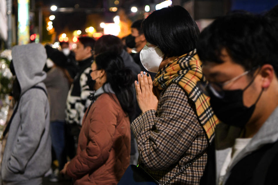 A woman prays near a makeshift memorial for the 156 people killed in a Halloween crowd crush in Seoul's Itaewon district on Nov. 5, 2022. (Kang Jin-kyu / AFP - Getty Images)