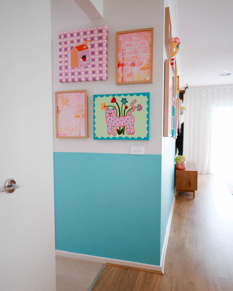 white and blue hallway with colorful gallery wall