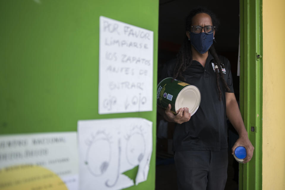 The coordinator of Comedores Sociales (Social Canteens), Giovanni Roberto, a non-profit entity dedicated to offering hot meals in the middle of the Covid-19 pandemic, carries supplies before handing out an order in Caguas, Puerto Rico, Wednesday, April 29, 2020. Puerto Rico's government is refusing to open school cafeterias amid a coronavirus pandemic as a growing number of unemployed parents struggle to feed their children. (AP Photo/Carlos Giusti)