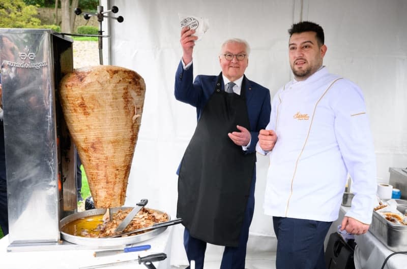 German President Frank-Walter Steinmeier (L) holds a kebab, which Steinmeier had previously cut from the spit under Keles' guidance, next to Berlin restaurateur Arif Keles at a reception hosted by the President in the garden of the German ambassador's historic summer residence. Bernd von Jutrczenka/dpa